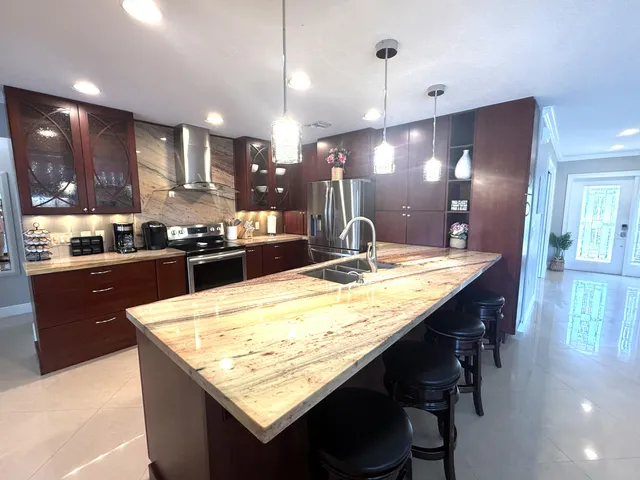 a kitchen with stainless steel appliances kitchen island granite countertop wooden cabinets and granite counter tops