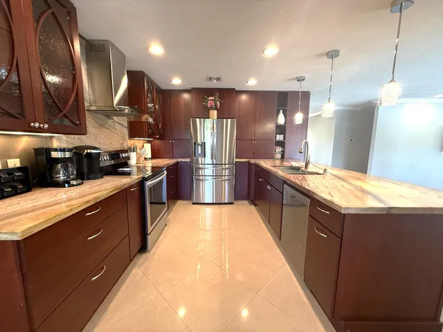 a large kitchen with stainless steel appliances kitchen island granite countertop a sink and cabinets