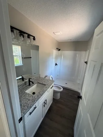 a bathroom with a granite countertop sink toilet and shower