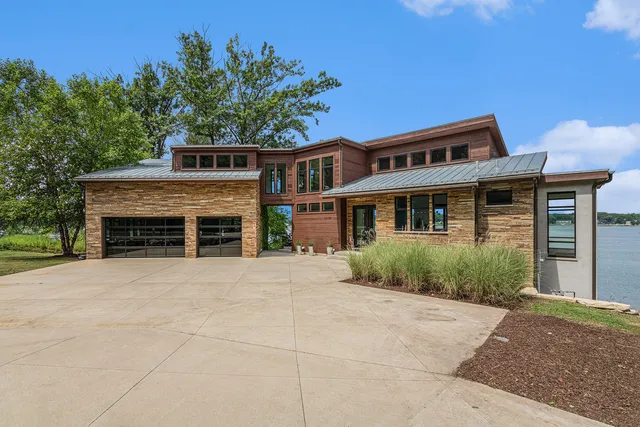 a front view of a house with a garden and trees