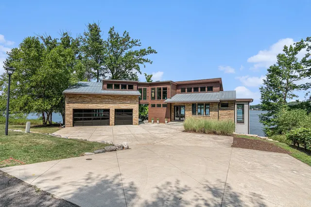 a front view of a house with yard and trees