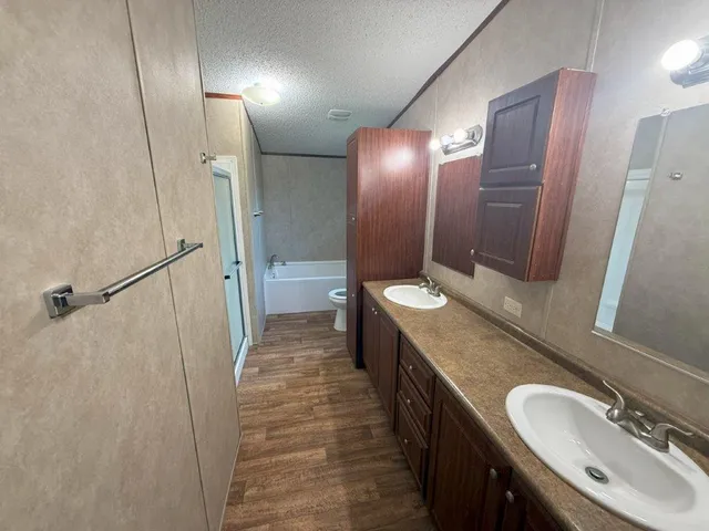 a bathroom with double vanity and a mirror