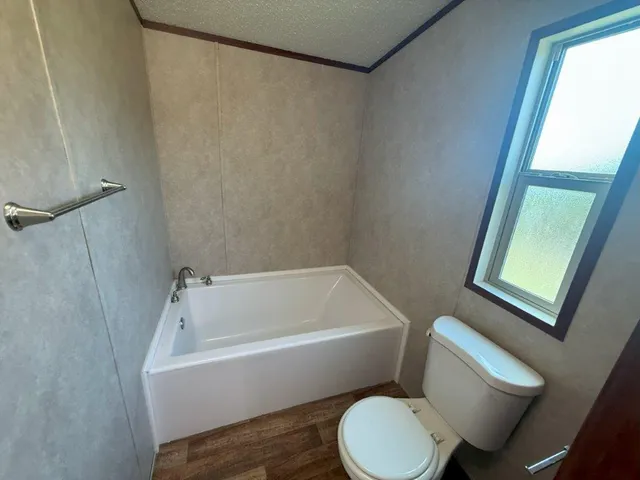 a white toilet sitting next to a bath tub