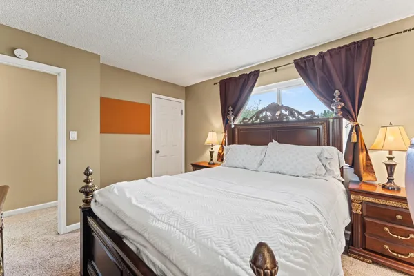 a bedroom with a bed and a painting on the wall