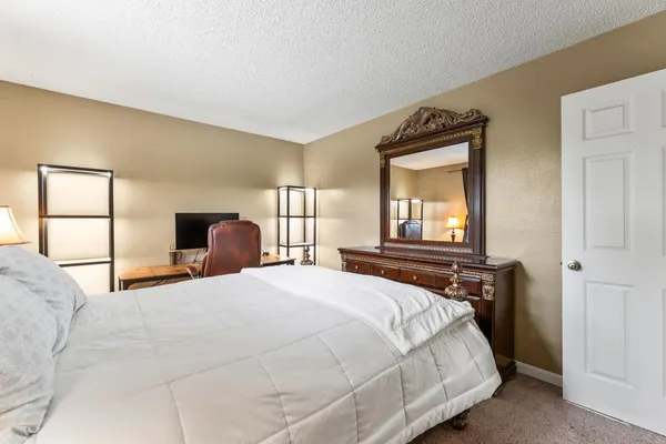 a bedroom with a bed and window with chair