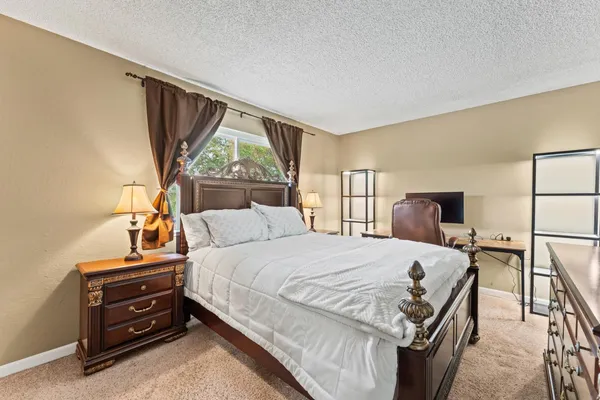 a bedroom with a bed and a flat tv screen on dresser