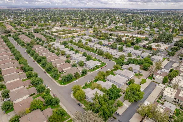 an aerial view of residential houses with outdoor space and street view