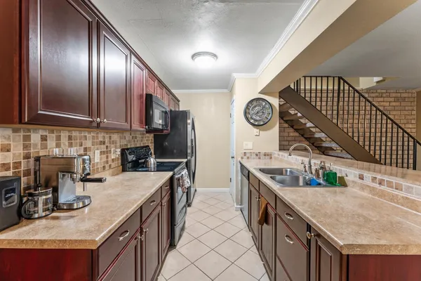 a kitchen with stainless steel appliances granite countertop a sink a stove and a wooden floors