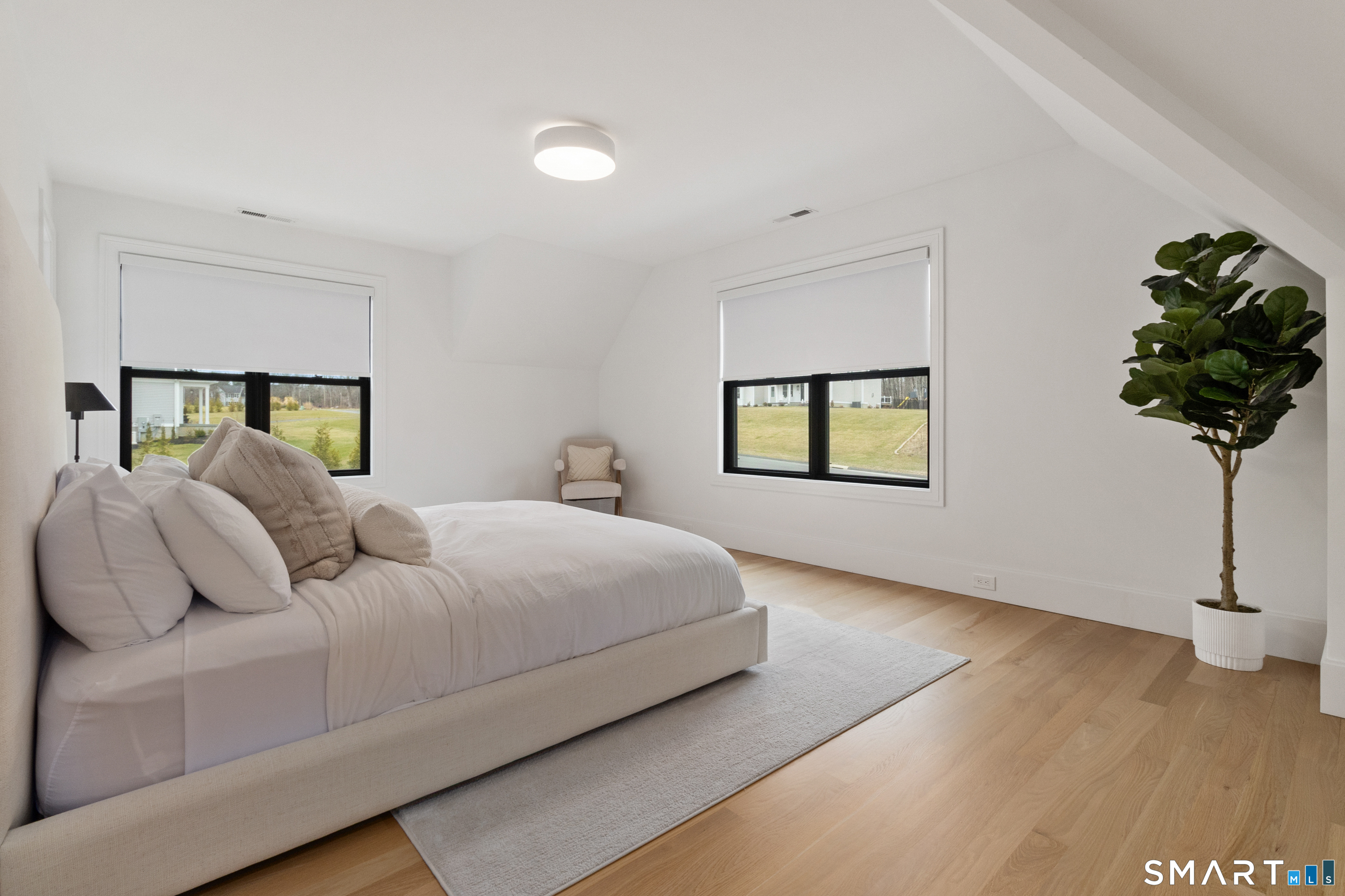 8 Holly Lane Newtown, CT 06482 - Photo 23 of 36 a bedroom with a bed and a potted plant