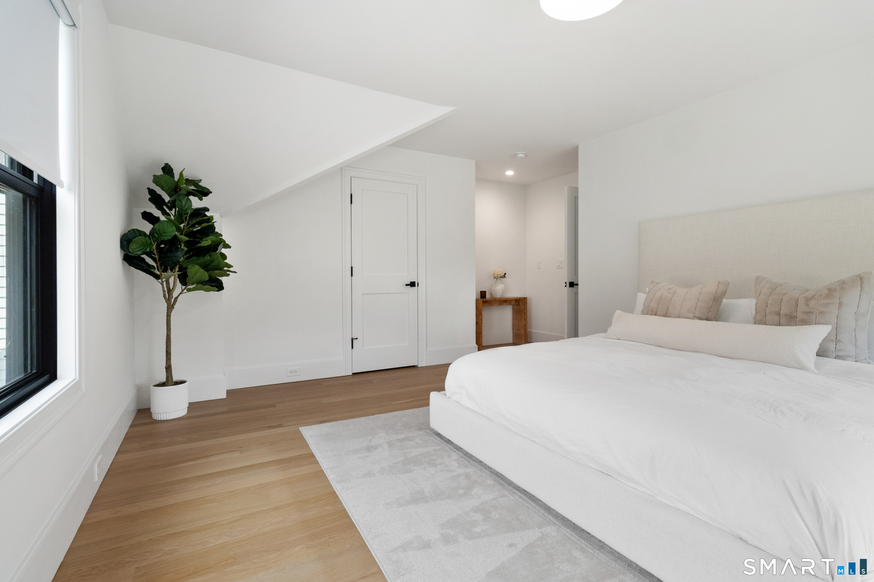 8 Holly Lane Newtown, CT 06482 - Photo 24 of 36 a spacious bedroom with a bed and a potted plant