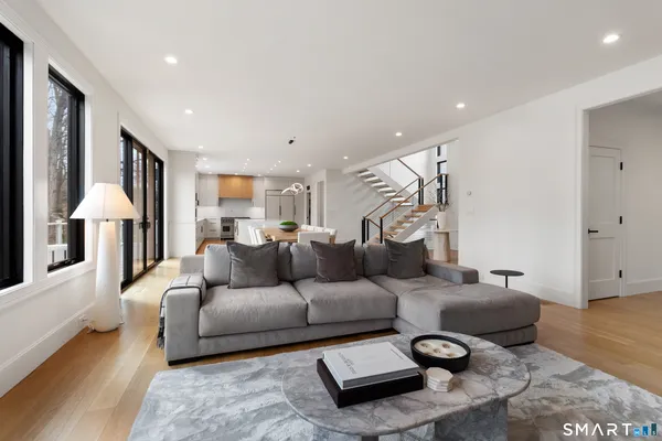 a kitchen with stainless steel appliances granite countertop a stove and a view of living room