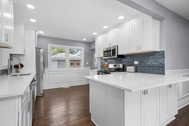 a kitchen with stainless steel appliances granite countertop a stove a refrigerator and a microwave