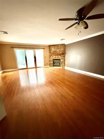a view of empty room with wooden floor and fireplace