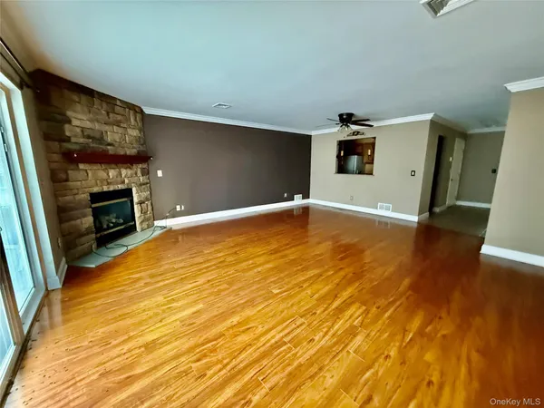 an empty room with windows and fan