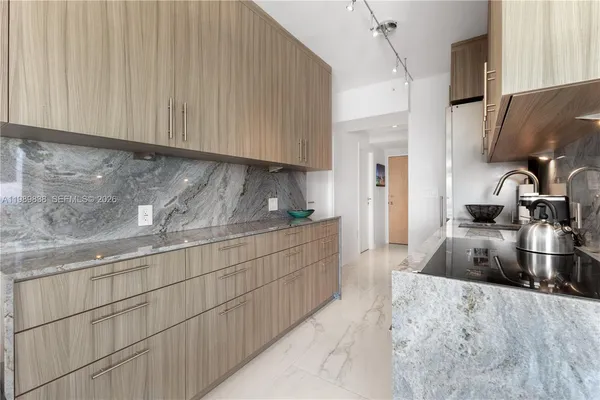 a kitchen with granite countertop a sink stove and cabinets