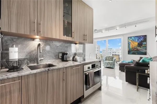a kitchen with stainless steel appliances granite countertop a sink stove and cabinets