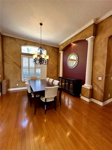 a view of a dining room with furniture wooden floor and a chandelier