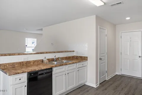 a kitchen with granite countertop a sink and cabinets