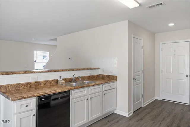 a kitchen with granite countertop a sink and cabinets