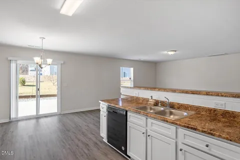 a view of a kitchen sink and wooden floor