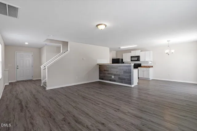 a view of kitchen with wooden floor electronic appliances and window