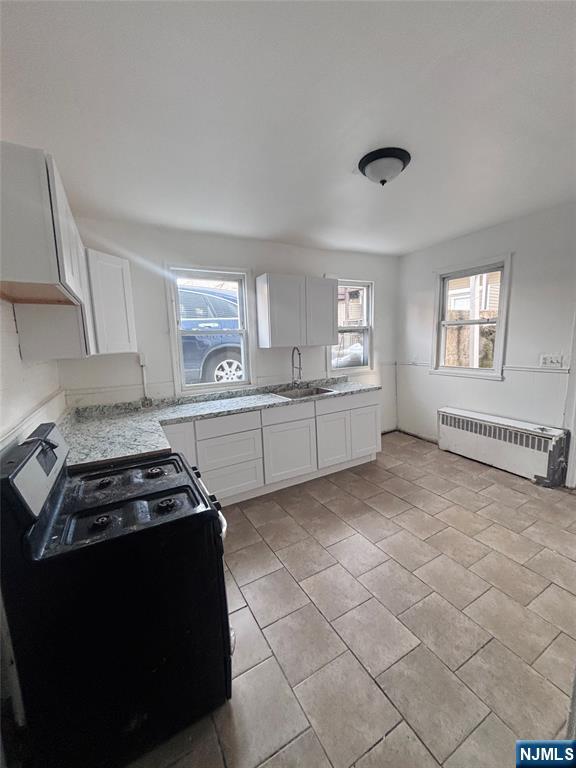9 Sparrow Street Paterson, NJ 07524 - Photo 6 of 20 a kitchen with a stove a sink and a refrigerator