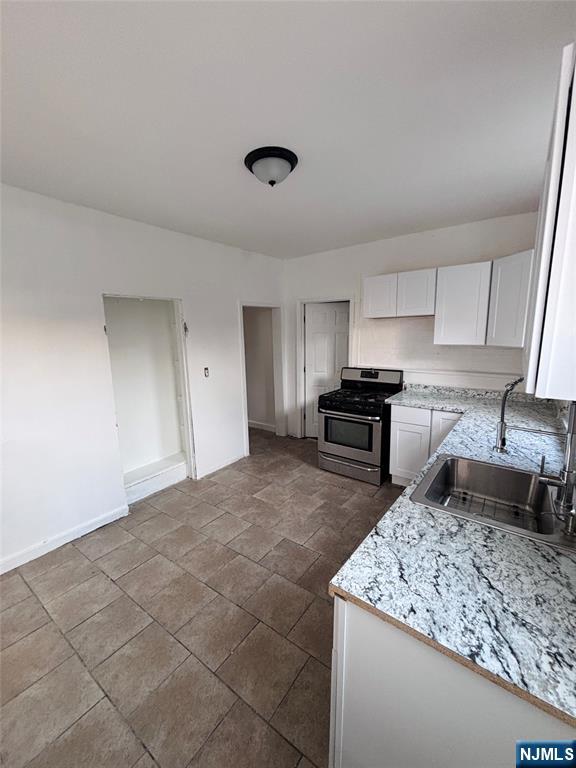 9 Sparrow Street Paterson, NJ 07524 - Photo 7 of 20 a kitchen with granite countertop a sink stove and cabinets