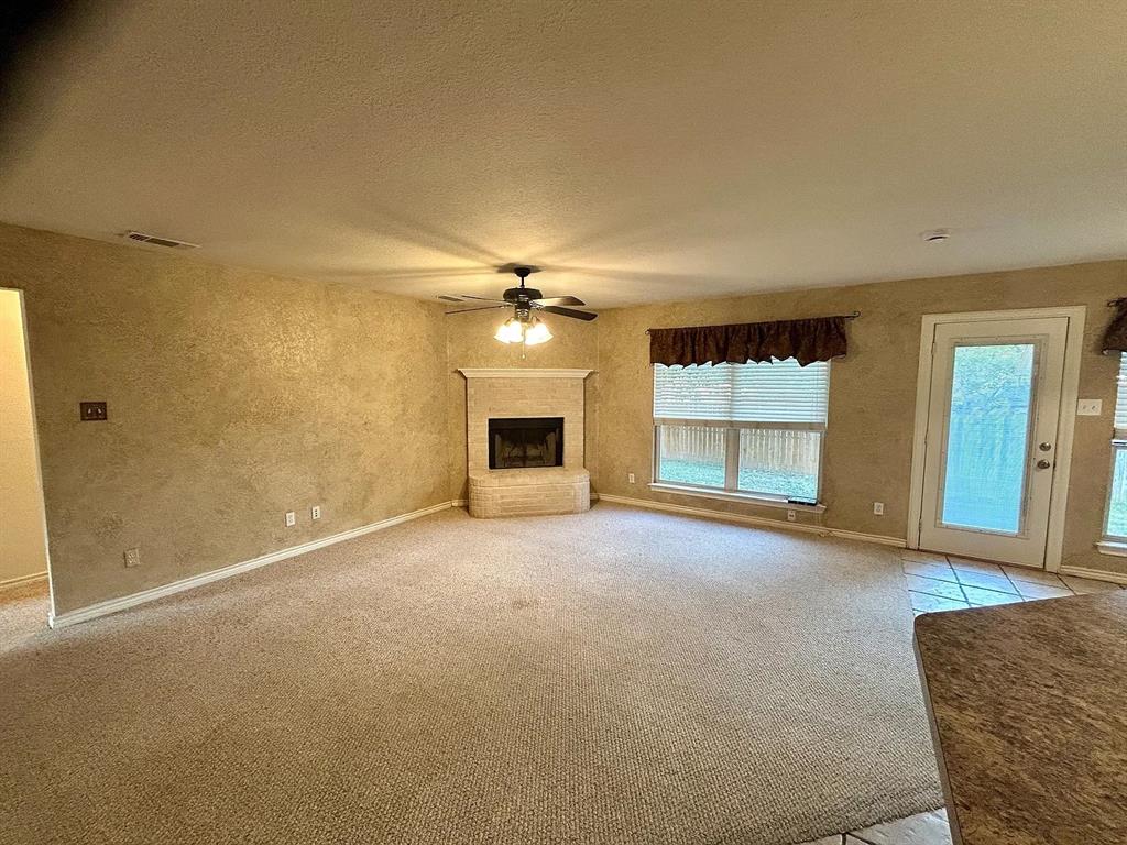 616 North Ave C Springtown, TX 76082 - Photo 2 of 13 an empty room with a fireplace and cabinet