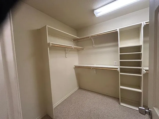 a view of walk in closet with empty racks
