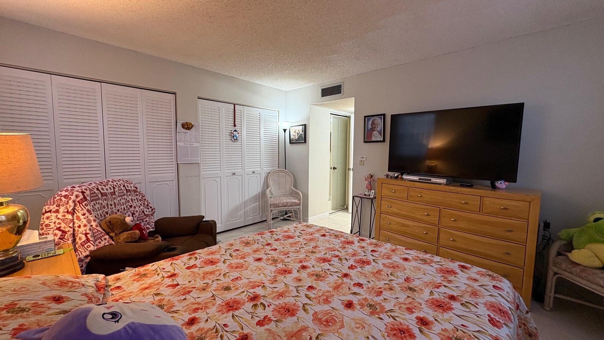 3070 Holiday Springs Boulevard, Unit 201 Margate, FL 33063 - Photo 14 of 30 a bedroom with a bed and a flat screen tv