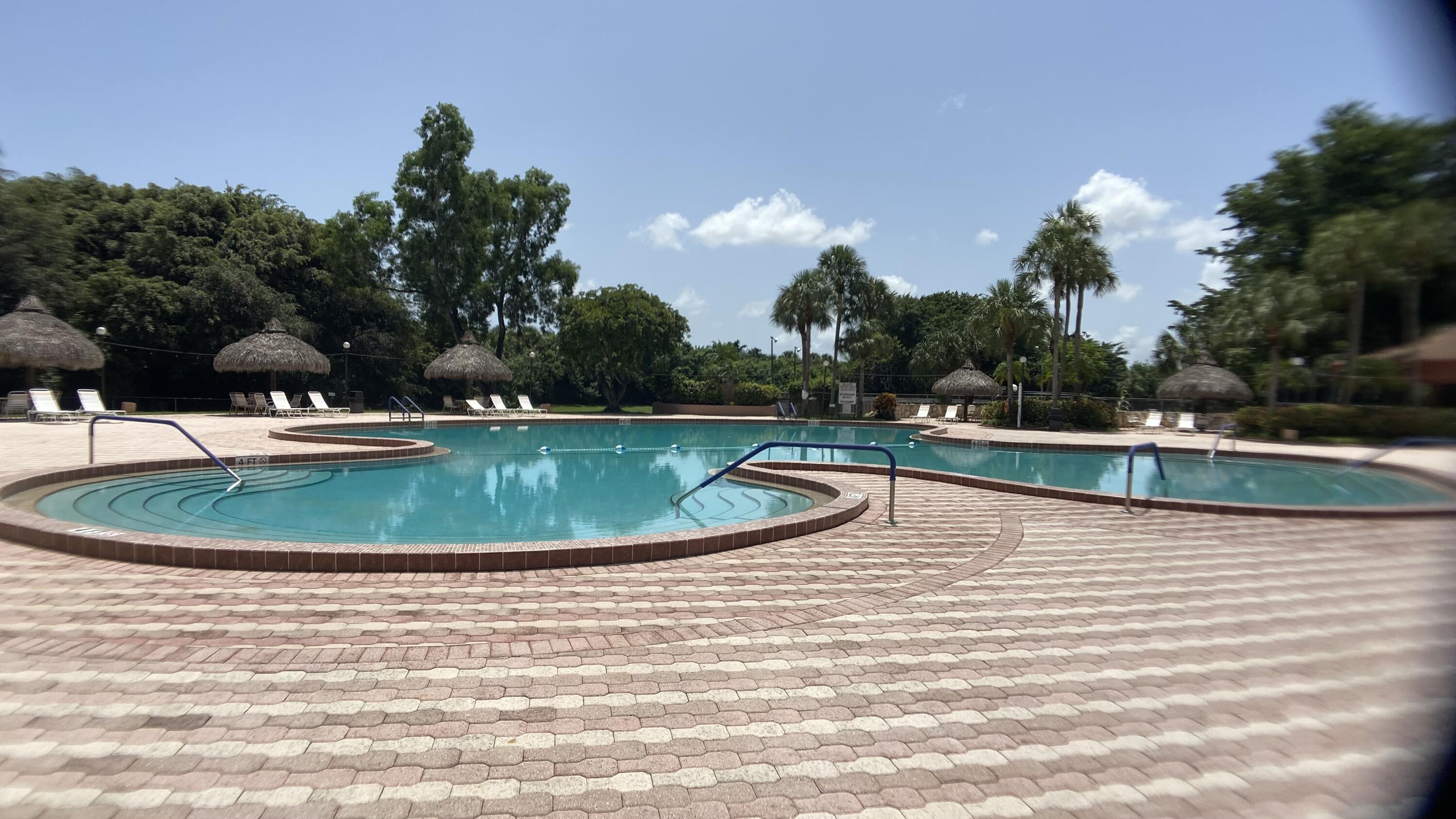 3070 Holiday Springs Boulevard, Unit 201 Margate, FL 33063 - Photo 26 of 30 a view of a swimming pool with a yard