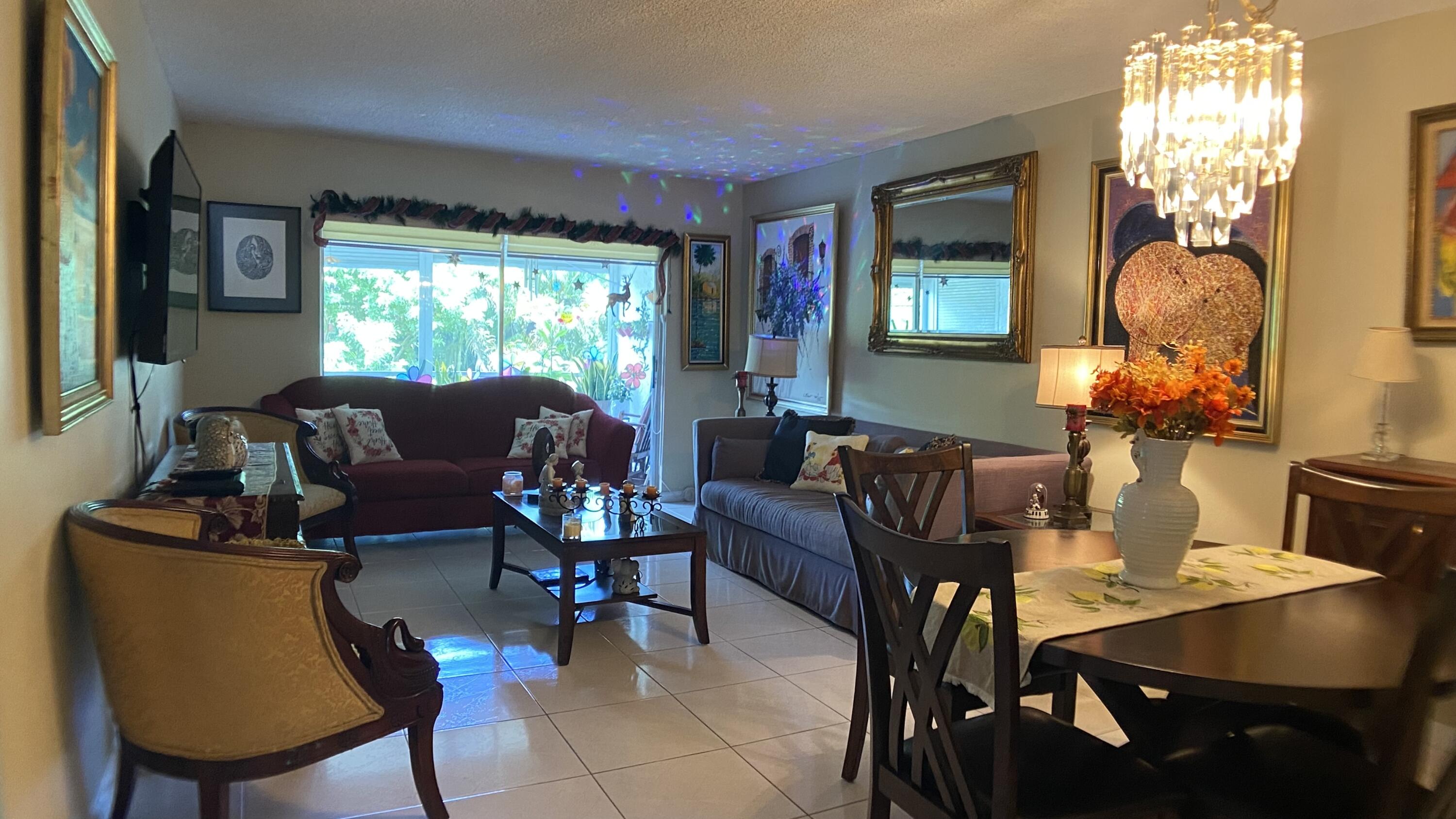 3070 Holiday Springs Boulevard, Unit 201 Margate, FL 33063 - Photo 10 of 30 a living room with furniture a window and a chandelier