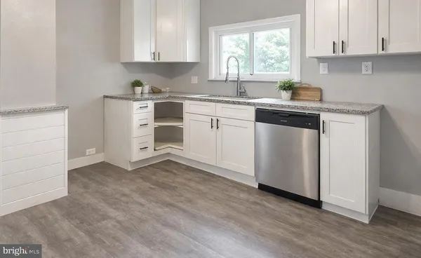 a kitchen with cabinets appliances a sink and a window