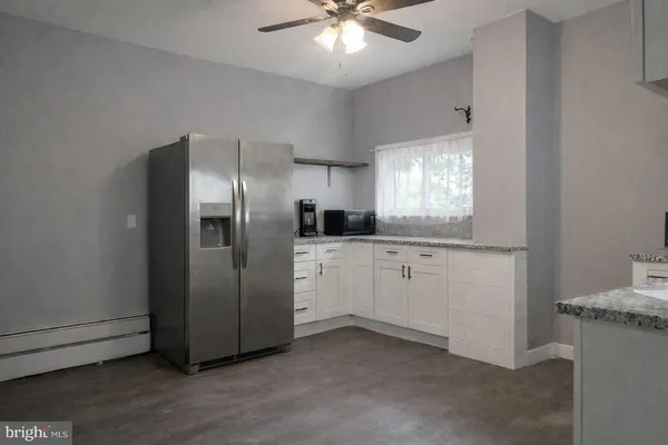 a kitchen with kitchen island a counter top space cabinets and stainless steel appliances