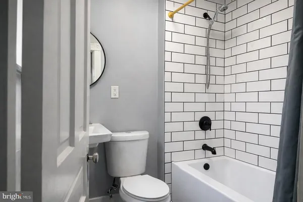 a white toilet sitting next to a shower