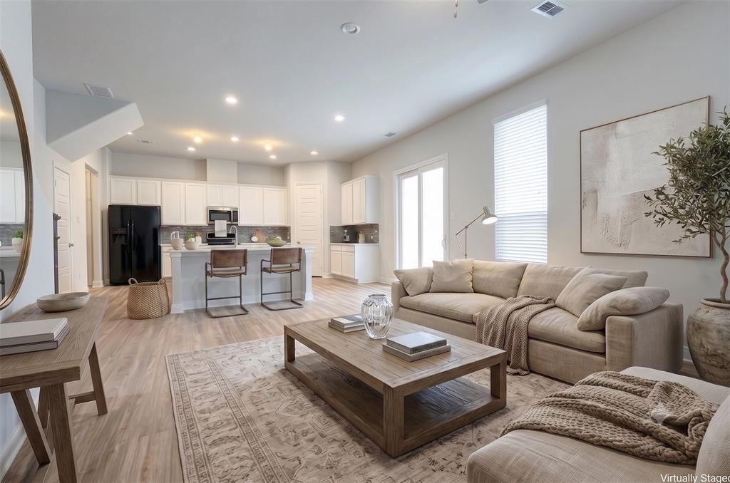 628 Ansley Way Allen, TX 75013 - Photo 2 of 20 Open-concept living area with wood-finish flooring, recessed lighting, and white window blinds
