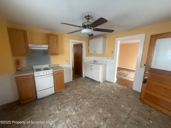 a kitchen with a stove top oven cabinets and a refrigerator