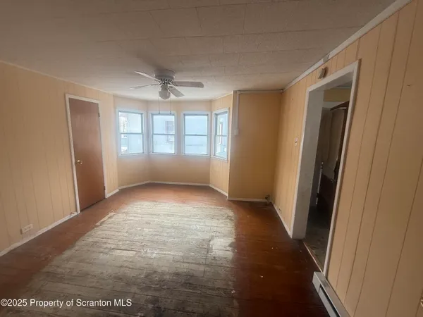 a view of a livingroom with a ceiling fan and window