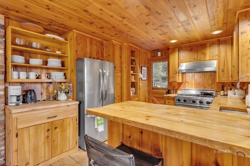 24631 Upper Rim Rock Road Idyllwild, CA 92549 - Photo 13 of 34 a kitchen with stainless steel appliances a stove a refrigerator a sink and cabinets