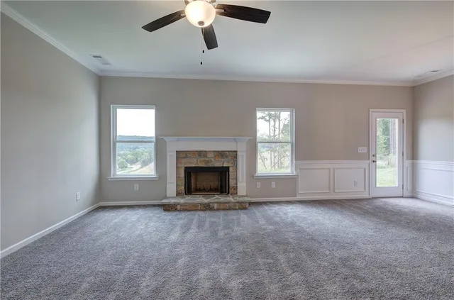an empty room with windows and fireplace