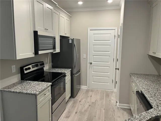 a kitchen with granite countertop a stove and a refrigerator