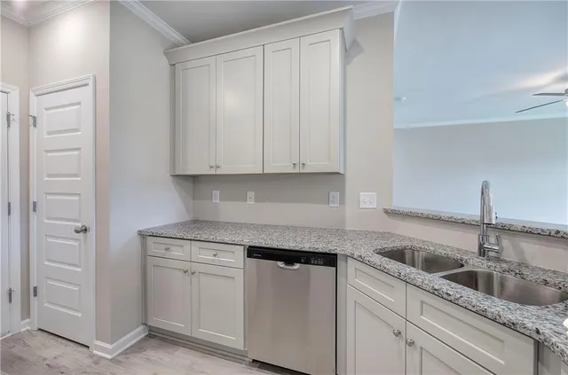a kitchen with white cabinets and sink