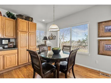 a dining room with furniture a chandelier and wooden floor