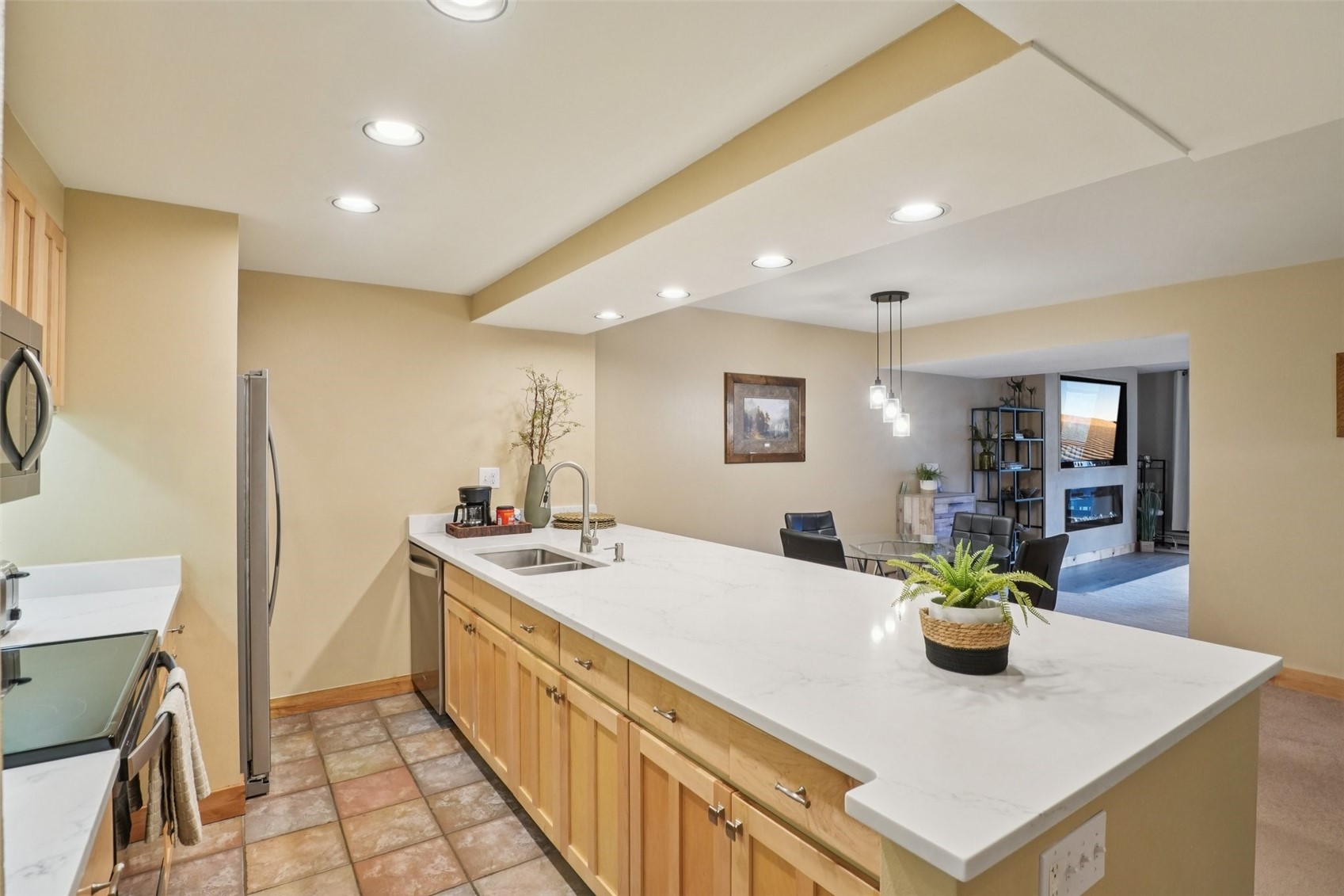 22097 Saints John Road, Unit 2506 Keystone, CO 80435 - Photo 12 of 47 Kitchen featuring a peninsula, recessed lighting, light brown cabinetry, light stone countertops, and appliances with stainless steel finishes