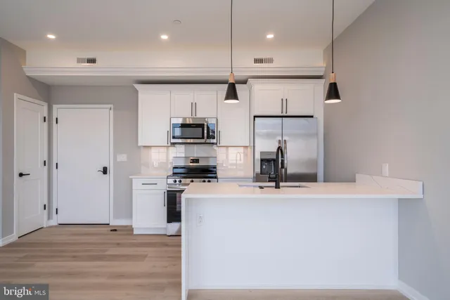 a kitchen with stainless steel appliances granite countertop a sink a stove and a refrigerator
