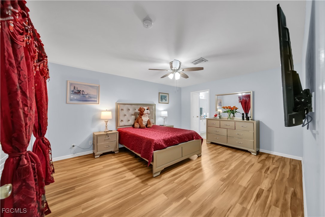 710 Homestead Road South Lehigh Acres, FL 33974 - Photo 11 of 38 a spacious bedroom with a bed and a flat screen tv