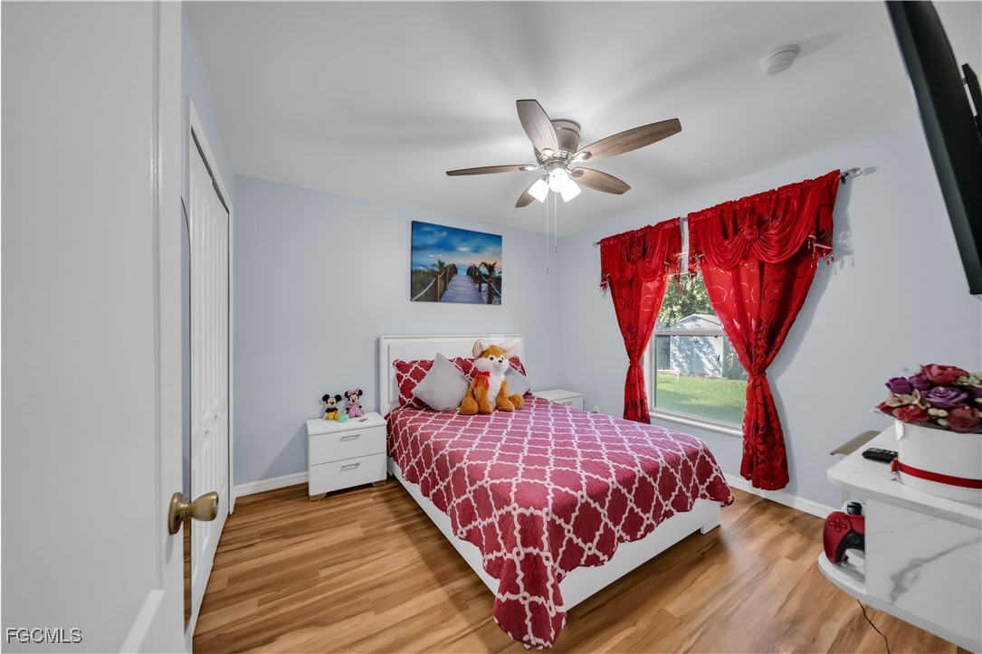 710 Homestead Road South Lehigh Acres, FL 33974 - Photo 17 of 38 a bedroom with a bed and wooden floor