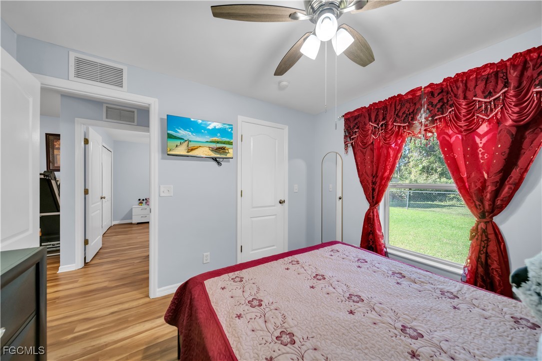710 Homestead Road South Lehigh Acres, FL 33974 - Photo 18 of 38 a view of a livingroom with wooden floor a ceiling fan and a kitchen