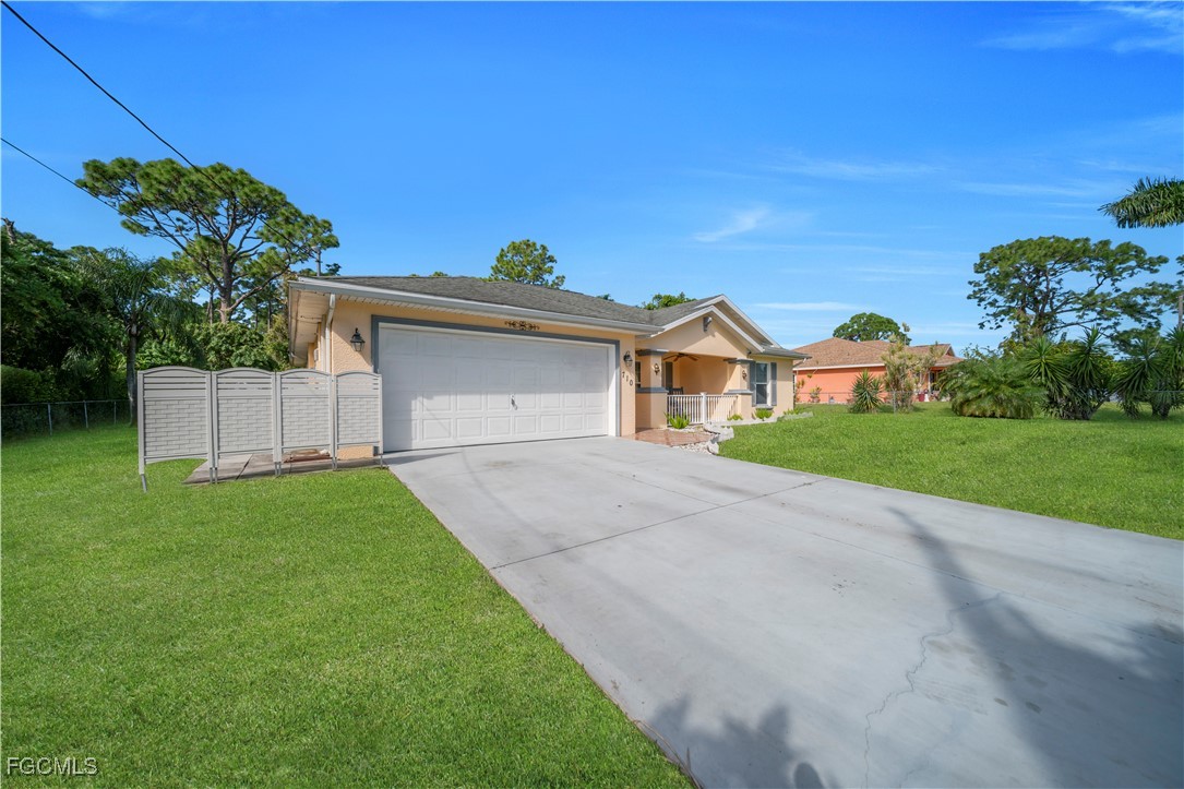 710 Homestead Road South Lehigh Acres, FL 33974 - Photo 2 of 38 a front view of a house with a yard and garage
