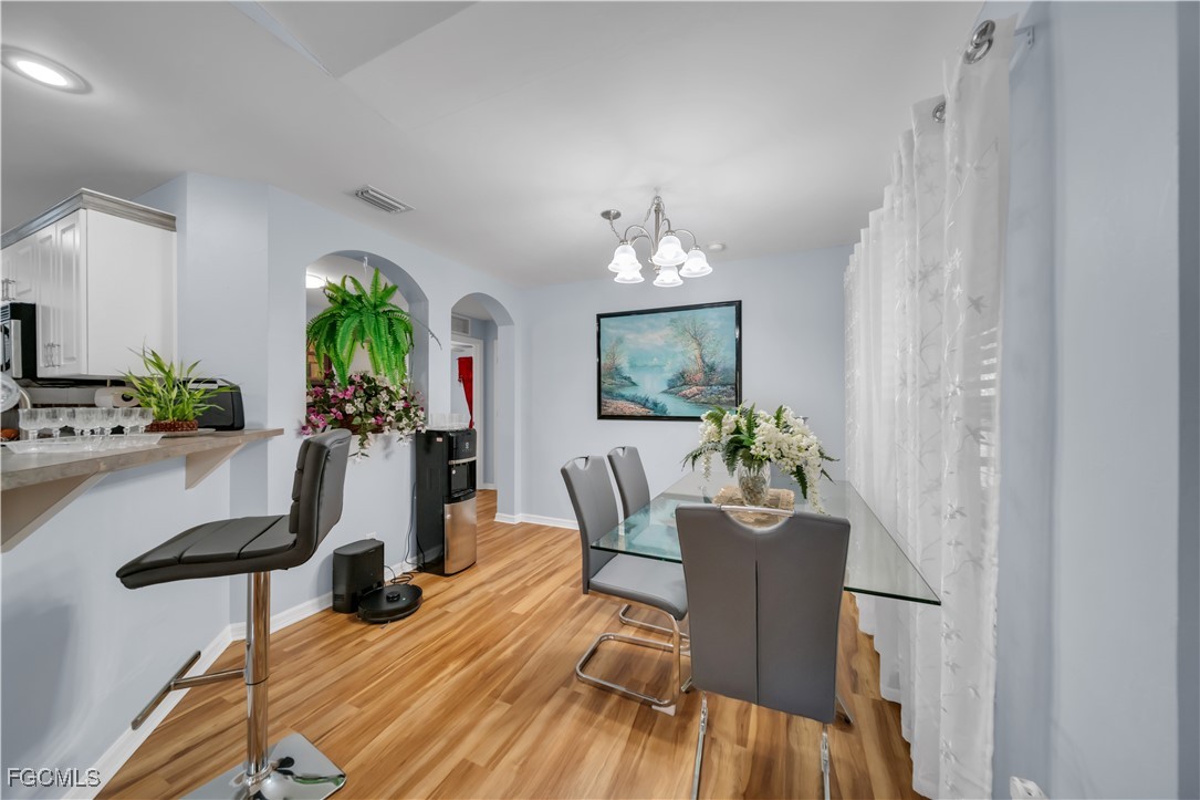 710 Homestead Road South Lehigh Acres, FL 33974 - Photo 23 of 38 a view of a dining room with furniture and a chandelier